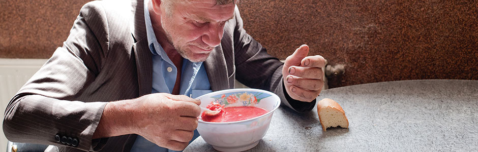 homeless man eating soup