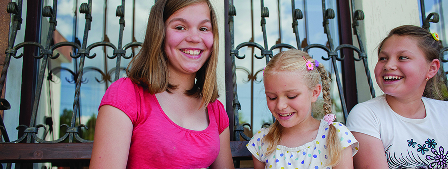 Girls from Birky smiling while holding a white rabbit