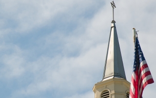 american flag next to a church
