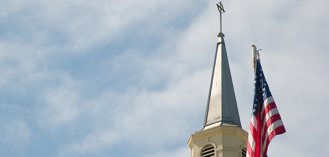 american flag next to a church