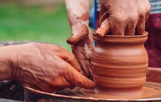 father teaching son on a potter’s wheel